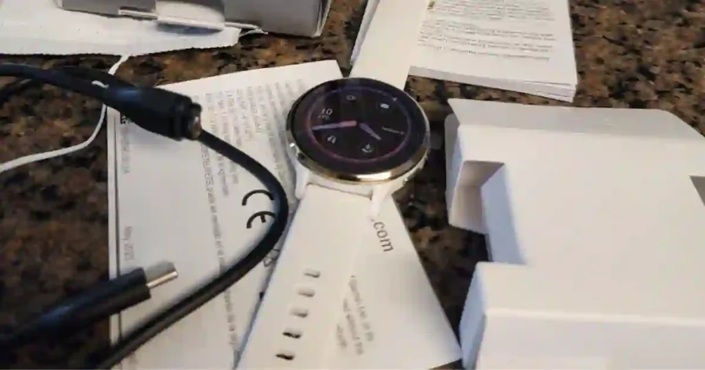 The unboxing of the Garmin Venu 3 showing the smartwatch, USB-C charger, and user manuals.